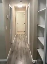 You can go down the hallway that guides you to the second and third bedroom with the laundry at the end of the hallway. Inviting you into a functional and well-connected space.