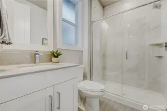 A stylish ensuite bathroom complements the spacious second bedroom on the upper floor.