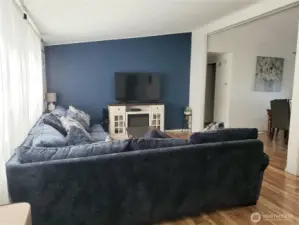 A View of the Enormous Open Living Room with Cathedral Ceiling, Newer Laminate Flooring Looking at the Entertainment Center from the Front Entry Door.