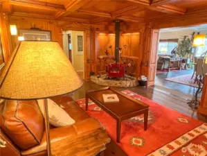 Luxurious parlor complete with a beautiful free-standing stove and masterfully created knotty pine walls, ceiling and decorative molding.