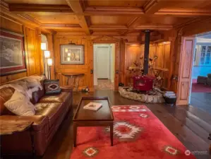 Luxurious parlor complete with a beautiful free-standing stove and masterfully created knotty pine walls, ceiling and decorative molding.