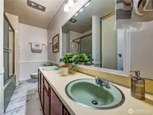Spacious full bathroom featuring dual sinks and a double linen closet for generous storage