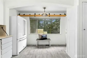 Another shot of the kitchen's eating area, to the right of the window, you can barely see the doorknob for the double hung door that leads to the deck--perfect for al fresco dining.  Don't miss the original iron board located in the cupboard to the right.