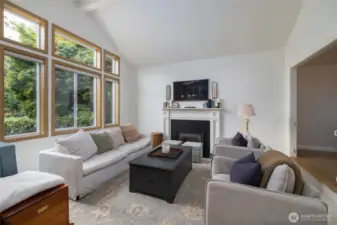Living room w/vaulted ceiling and natural gas fireplace insert.