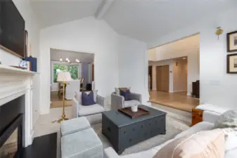 Living room, looking into the dining room at back and entry at right.