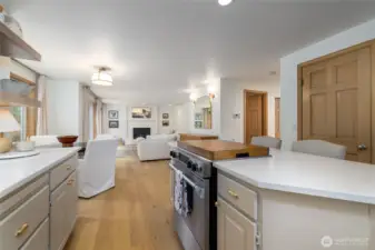 A view from the kitchen through the breakfast nook to the family room.  Closed door at far right is the step-in pantry, open door at left is the main floor powder room.