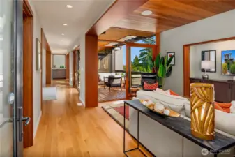 Natural light pours through wide glass doors, connecting open living spaces to a sun-soaked outdoor deck.