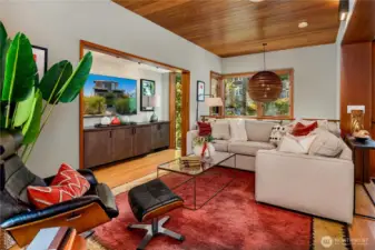 Warm wood ceilings and custom details create a living room that balances modern design with comfort.