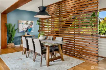 A striking wood-slat architectural screen adds warmth and style to the dining room’s clean modern lines.
