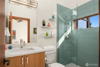 A playful pop of color elevates this stylish second bedroom bath, complete with custom tile and natural light.