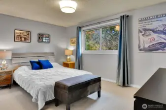 The primary suite offers a restful retreat, featuring a large window framing peaceful backyard views.