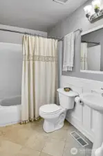 And here's the full primary bath, which includes a pedestal sink and charming wainscoting detail.