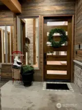 Welcoming covered front porch with modern glass door.