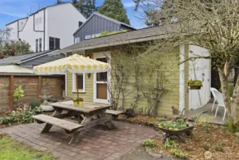 Out back, a level yard creates an easy extension of living space, complemented by a detached office w/ electricity—an inspired solution for remote work, studio use, or creative pursuits. Take a break for lunch on the brick patio with a picnic table seating area.