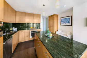 Huge kitchen island with beautiful granite slab counters and backsplash. Sweet seating nook too.