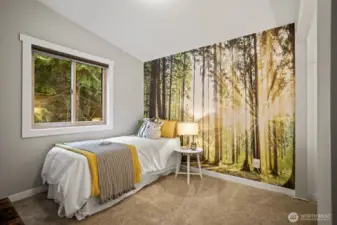 Charming second bedroom with vaulted ceiling and stylish wallpaper accents.