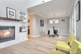 Formal living room w/ gas fireplace & built-in bookcase open to Dining room
