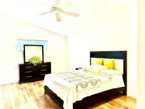 Large master bedroom with hardwood floors, vaulted ceiling, and ceiling fan.