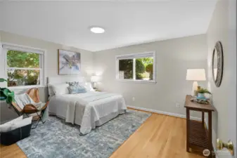 Spacious primary bedroom on the main floor, offering tranquil views of the serene backyard.