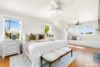 Head upstairs to one of two bedrooms - primary first! The light in here and space - perfection. This is a king sized bed with large furniture. and there's still so much space. Note the built-ins under the windows - storage all around!