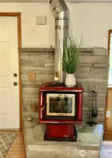 Wood stove in living room with stone surround.