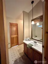 View of primary bath vanity.  Door offers easy access to laundry room.
