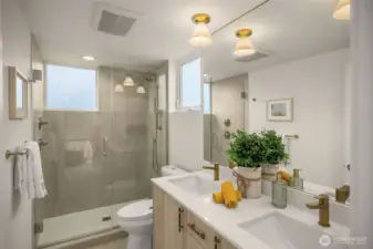 Primary bath with dual vanities and walk-in shower.