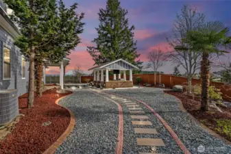 As you move through space, a lighted walkway gently guides you, illuminating the path and adding an enchanting glow to the night. Massive landscape borders and carefully placed rocks add texture and sophistication, framing the outdoor kitchen in nature’s finest elements. All of this is set against the backdrop of the majestic Mt. Rainier, its snow-capped peak rising above, offering a breathtaking view that turns every moment spent in this outdoor haven into something truly spectacular. Whether hosting a large gathering or enjoying a quiet evening, this outdoor space is a true sanctuary where luxury, nature, and beauty converge.