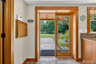 French doors lead to the spacious backyard with patio space, vegetable and flower garden, shaded dog run and large lawn.