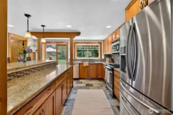 Modern kitchen with gas stove, stainless steel appliances and cherry wood 15 in. deep cabinents.