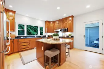 Wow! The owners re-imagined the kitchen wing and created a gorgeous kitchen with tons of storage and a large window, overlooking the sylvan setting. Detached garage seen through the door.