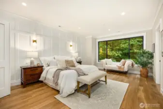 Primary Bedroom: French door entry, 5” plank white oak floors, Full wall panels add a dramatic effect and create a warm and cozy atmosphere, Generously proportioned with an oversized picture window overlooking the beautiful territorial view