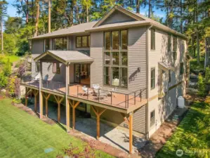 The back of the house boasts a partially covered massive deck and plenty of room to run around on the grassy lawn.