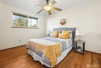 Good sized primary bedroom with a wall of closets. Original hardwood floors here and ceiling fan.