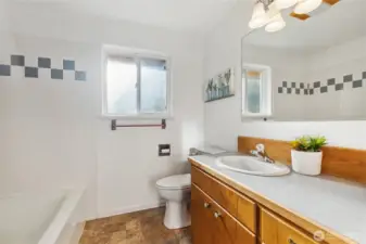 Spacious bathroom with tub/shower combination on the left, plus to the right out of the photo is floor to ceiling storage with so much ROOM!