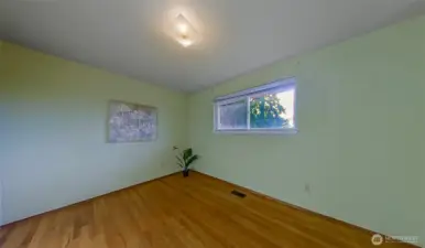 Bedroom#3, original hardwoods, looks out to the backyard.