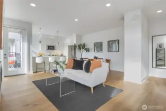 Living area with hardwood floors and recessed lighting.