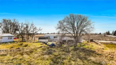 This property has a nice big tree on it, a shed, septic system, and electricity.  It's mostly fenced. The house right next door is occupied and not part of the vacant land listing. (Please don't knock on the door of the tenant's home next door.)