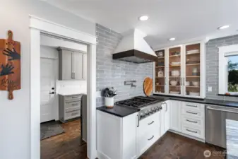 Thermador gas stove; glass-fronted cabinets; utility room beyond