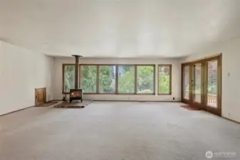 Large Living Room with wood burning stove and door leading out to the large back deck.