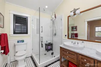 Luxurious walk-in shower has a seamless glass door with subway tile for an elevated style.