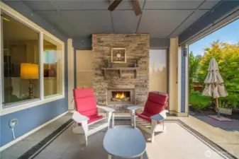 Enjoy the large, covered patio with the inviting stone fireplace overlooking your backyard sanctuary!  Motorized privacy screens on the sides and a motorized shade screen to the South.