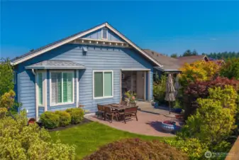 Beautiful hardscape extends the covered patio area and mature plantings provide privacy on the Southern facing lot.