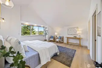 Generously sized primary bedroom with vailted ceilings, walk in closet, and en-suite bathroom