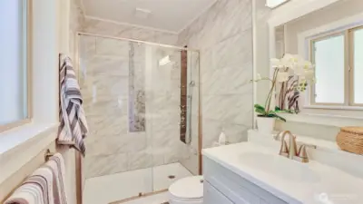 The primary bath en suite offers a beautiful tile walk in shower.