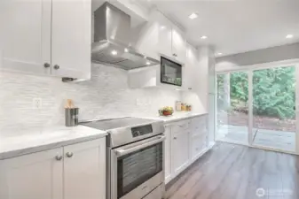 Timeless kitchen with tile backsplash, stone countertops, stainless appliances, modern range hood, can lights, and so much more.