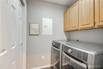 Utility room with newer washer and dryer, storage and sliding door for separation from kitchen.