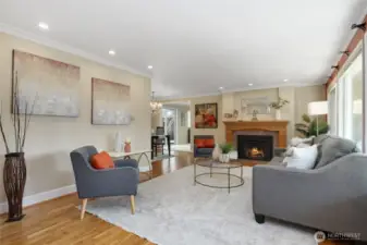 Light filled living room with original oak floors and gas fireplace
