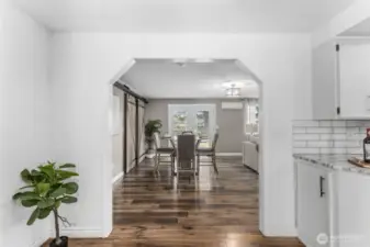 Plank flooring flows throughout home leading into eating area and second living area