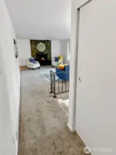 Hallway from primary looking to living room, hall bath to the left.